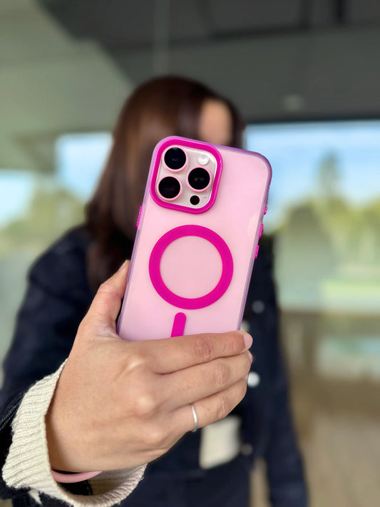Mujer sosteniendo iPhone con carcasa rosada mostrando MagSafe, anillos de cámara y diseño elegante
