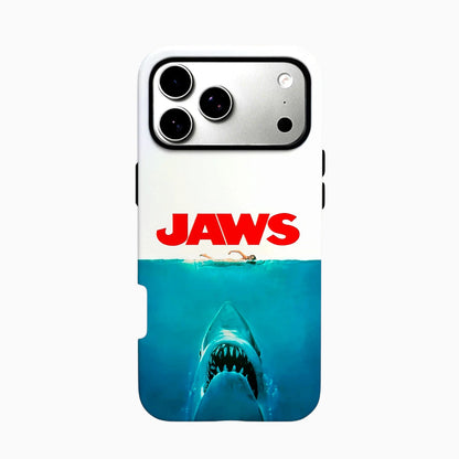 Carcasa JAWS para iPhone con un tiburón de fauces abiertas bajo una nadadora, fondo blanco, océano azul y título rojo.